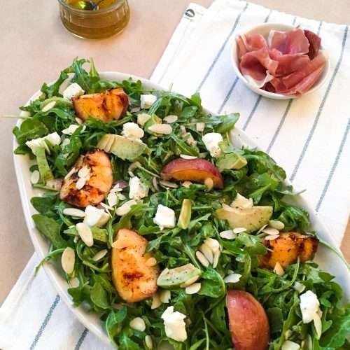 Salade pêches, roquette, chèvre et miel avec prosciutto